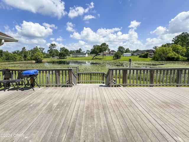 wooden terrace with a water view and a grill