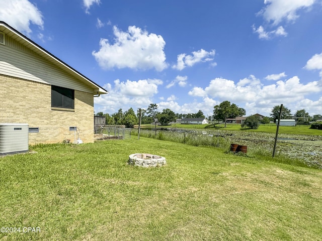 view of yard featuring central AC and a fire pit