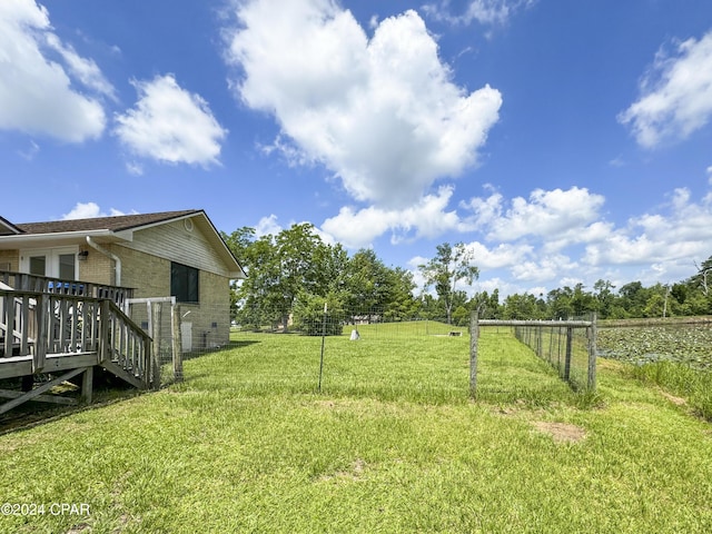 view of yard featuring a rural view and a wooden deck