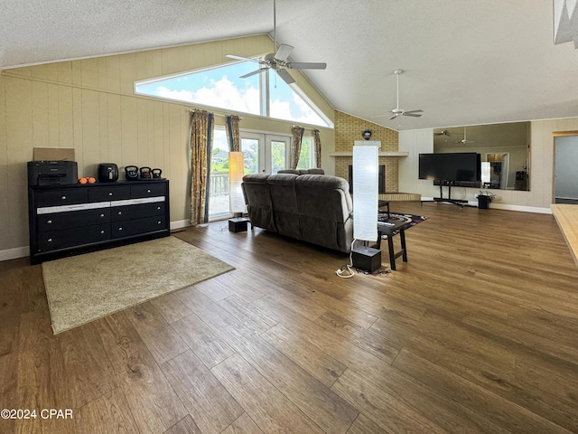 living room with lofted ceiling, dark wood-type flooring, wooden walls, and french doors