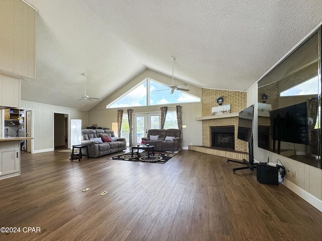 living room with high vaulted ceiling, french doors, a brick fireplace, ceiling fan, and dark hardwood / wood-style flooring