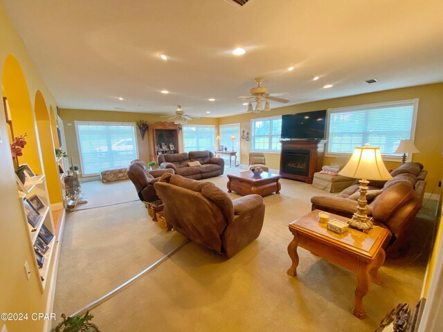 carpeted living room with ceiling fan