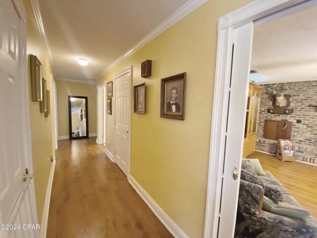 hallway featuring hardwood / wood-style flooring and crown molding