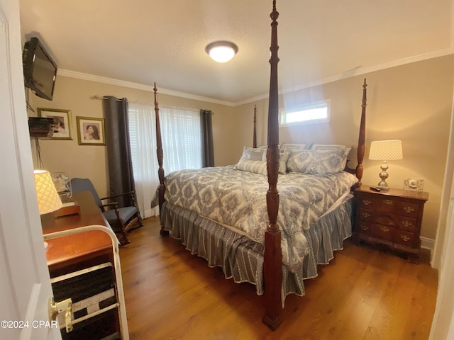 bedroom with ornamental molding and hardwood / wood-style flooring