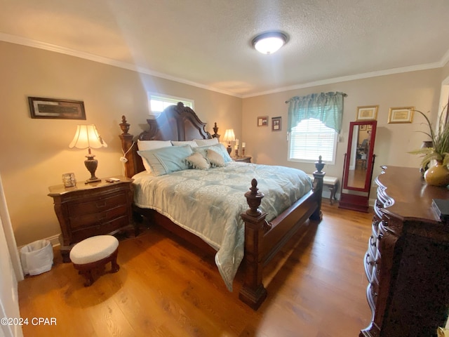 bedroom with hardwood / wood-style flooring, ornamental molding, and a textured ceiling