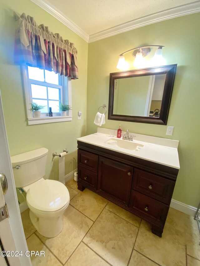 bathroom with ornamental molding, tile flooring, toilet, and vanity