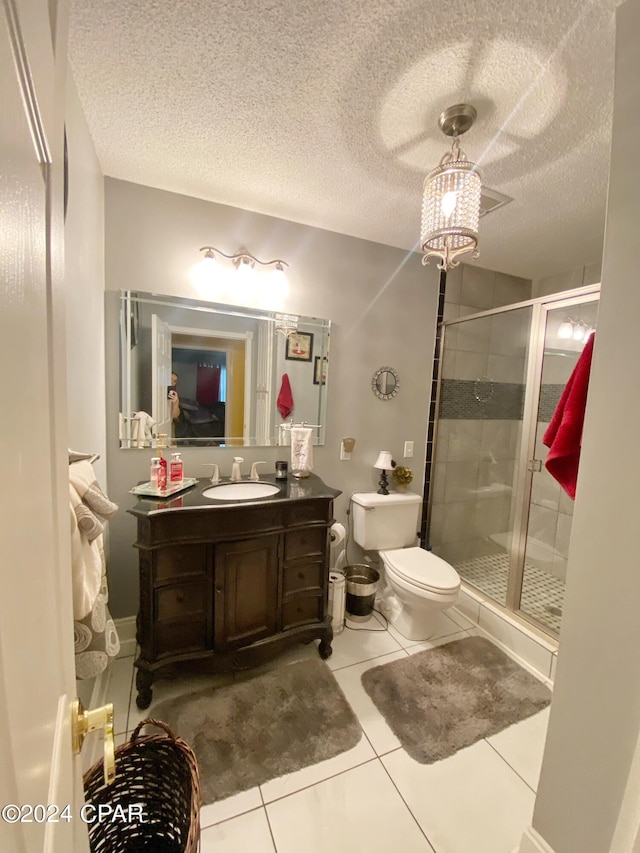 bathroom featuring toilet, vanity, a textured ceiling, and tile floors