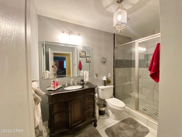 bathroom featuring tile flooring, a textured ceiling, toilet, and vanity