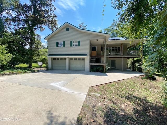 view of front of house featuring solar panels, a porch, and a garage