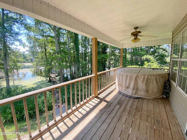 deck with a water view and ceiling fan