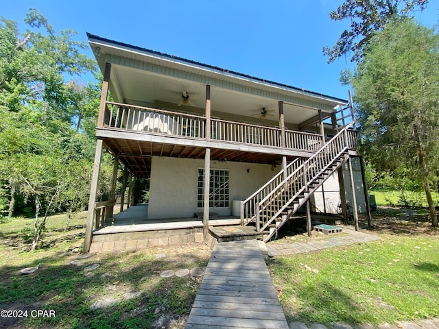 back of property featuring ceiling fan, a patio area, a yard, and a deck