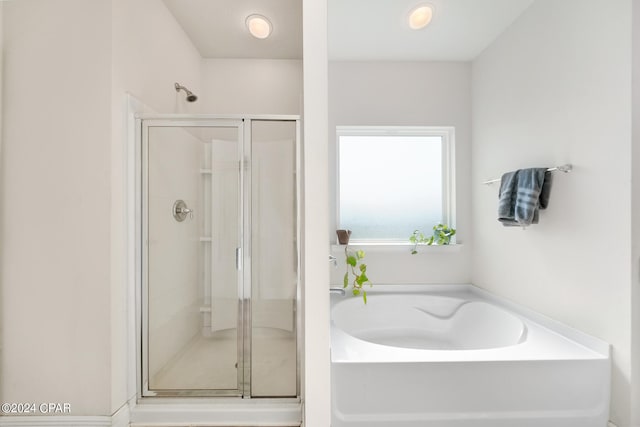 bathroom featuring shower with separate bathtub