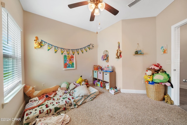 carpeted bedroom featuring multiple windows and ceiling fan