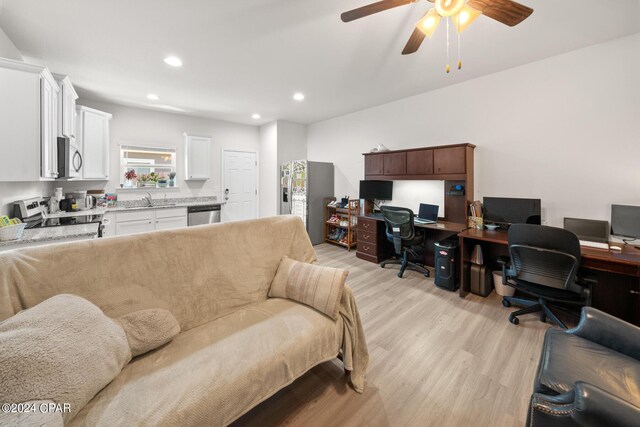 living room with sink, ceiling fan, and light wood-type flooring