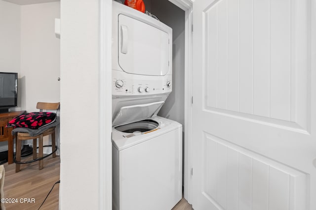 washroom featuring stacked washer and clothes dryer and light hardwood / wood-style flooring