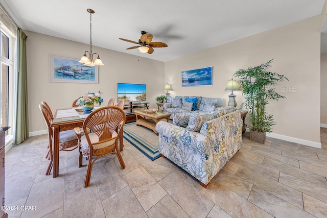 living room featuring ceiling fan with notable chandelier