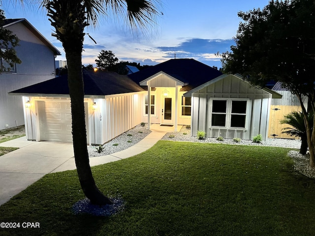 view of front of house with a garage and a yard