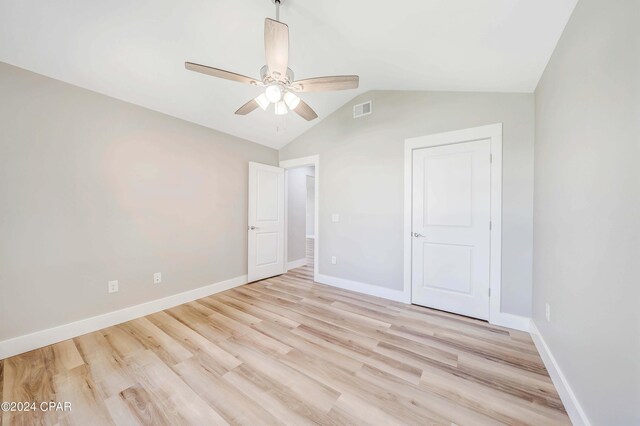 unfurnished room with lofted ceiling, ceiling fan, and light wood-type flooring