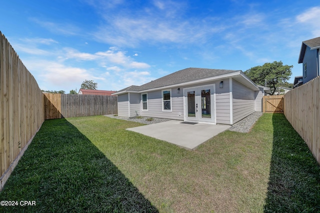 rear view of house featuring a lawn, a patio area, and french doors