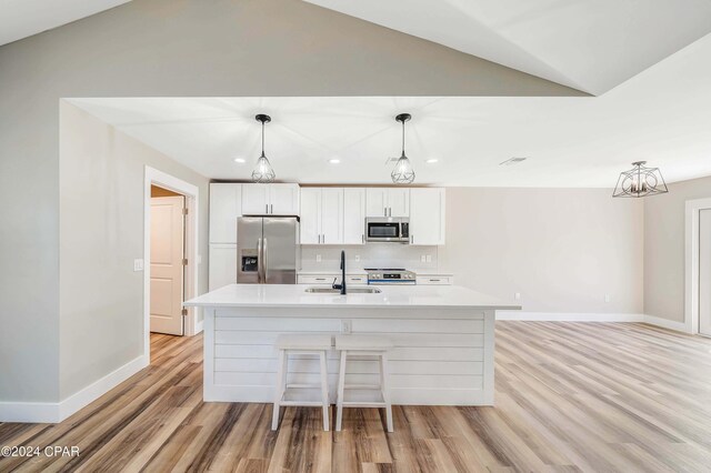 unfurnished living room with ceiling fan, vaulted ceiling, and light hardwood / wood-style flooring