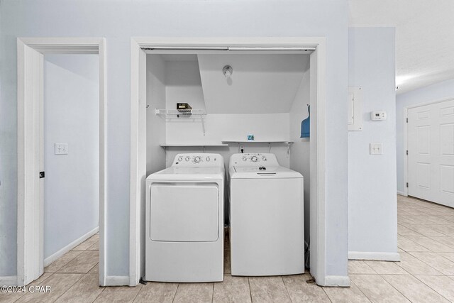 washroom featuring washer and dryer and light tile patterned flooring