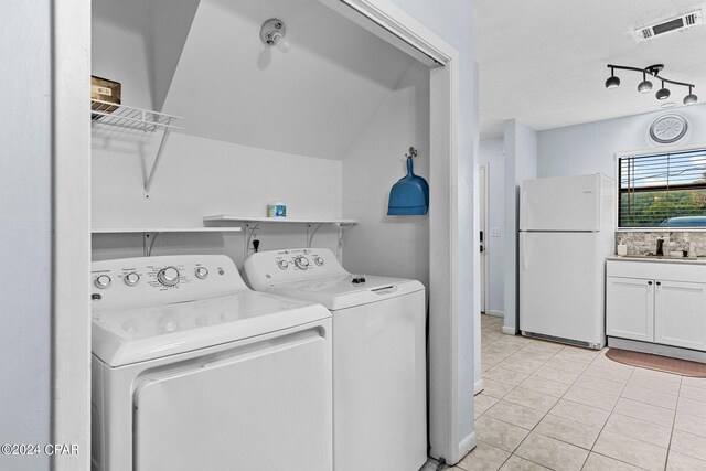 laundry room with sink, light tile patterned floors, and independent washer and dryer