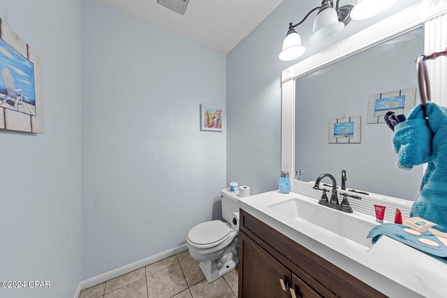 bathroom featuring tile patterned floors, vanity, a textured ceiling, and toilet