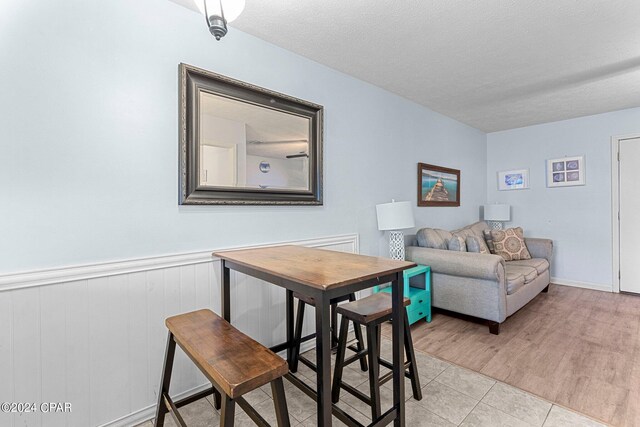 dining area with a textured ceiling and light wood-type flooring