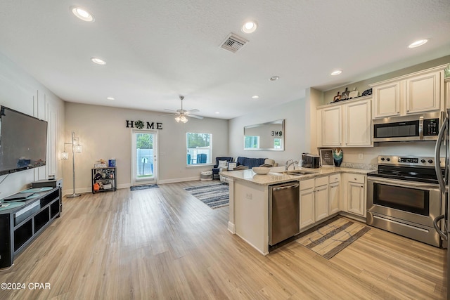 kitchen featuring kitchen peninsula, light stone countertops, stainless steel appliances, ceiling fan, and light hardwood / wood-style flooring