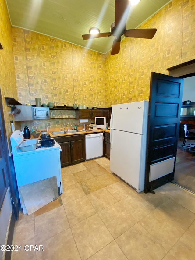 kitchen featuring ceiling fan, white appliances, dark brown cabinetry, light tile floors, and sink