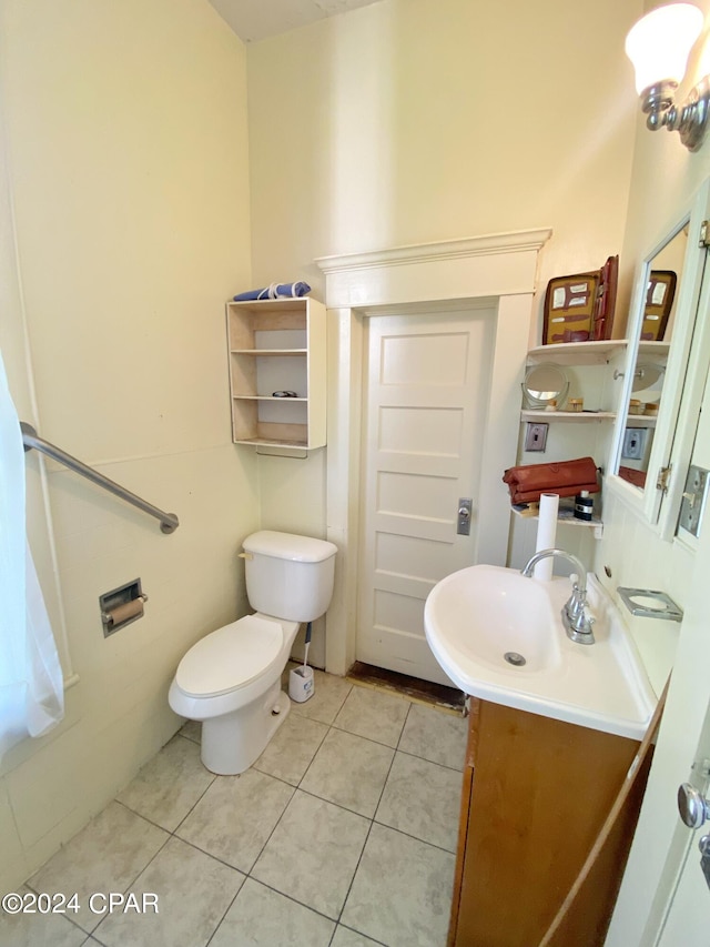 bathroom featuring tile flooring, toilet, and vanity