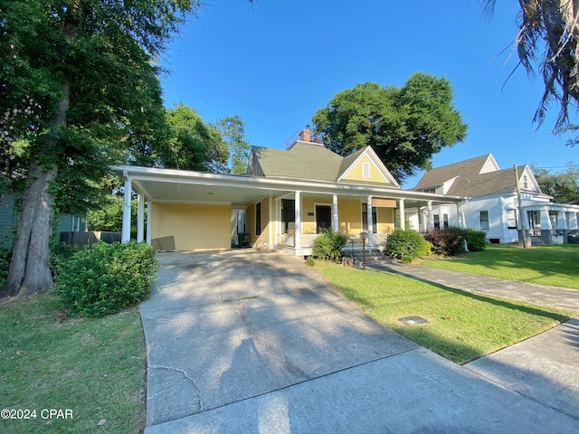 view of front of home featuring a carport, a front lawn, and covered porch