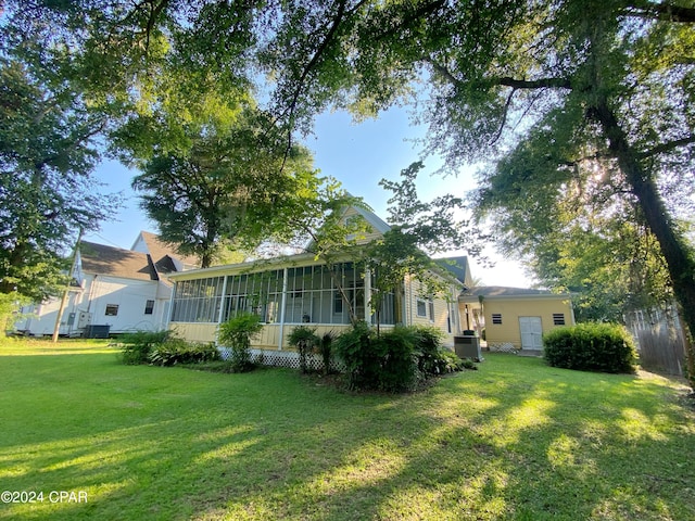 exterior space featuring a sunroom and a lawn