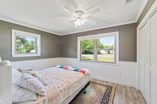 bedroom featuring multiple windows, a closet, and light wood-type flooring