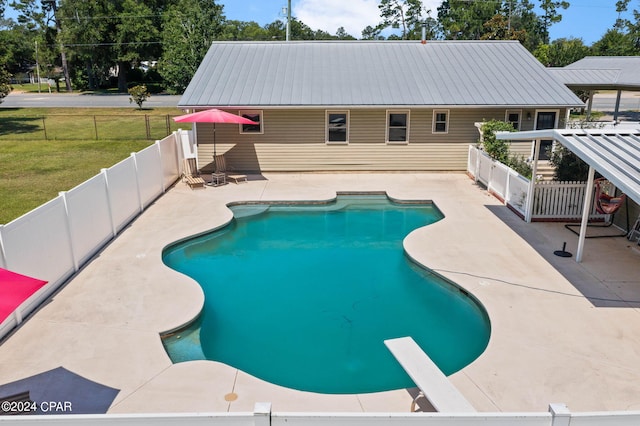 view of pool with a patio area and a lawn