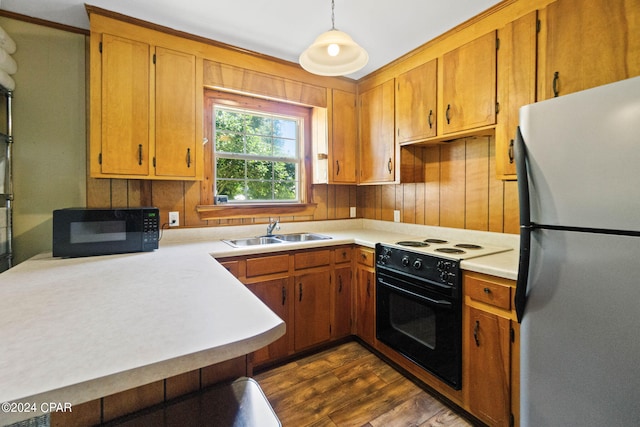 kitchen with stainless steel refrigerator, white range with electric stovetop, dark hardwood / wood-style floors, sink, and pendant lighting