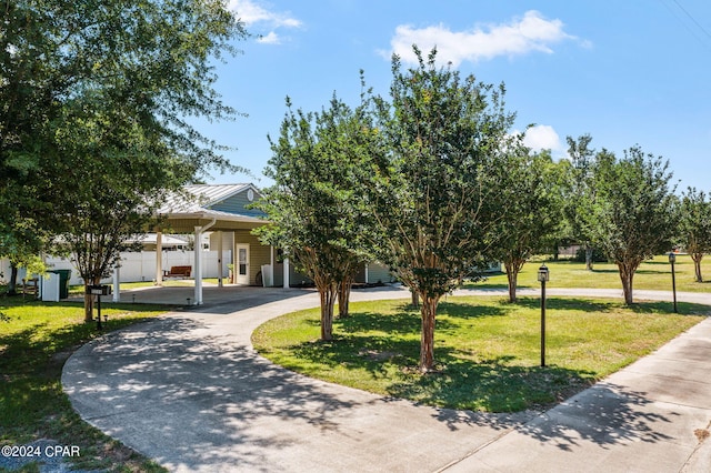 view of property hidden behind natural elements featuring a front lawn