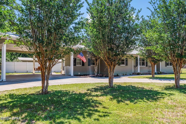 view of property hidden behind natural elements featuring a front yard