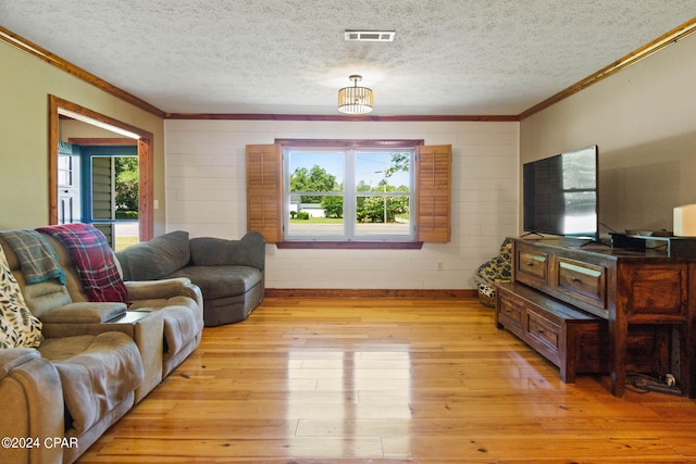 living room with plenty of natural light, a textured ceiling, and light wood-type flooring