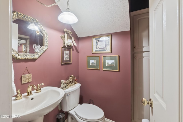 bathroom featuring toilet, sink, and a textured ceiling