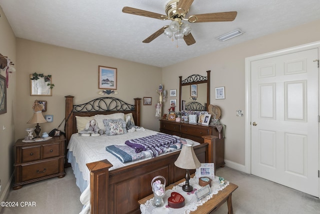 carpeted bedroom featuring a textured ceiling and ceiling fan