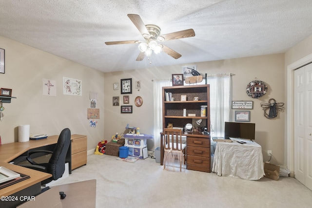 carpeted office space with ceiling fan and a textured ceiling