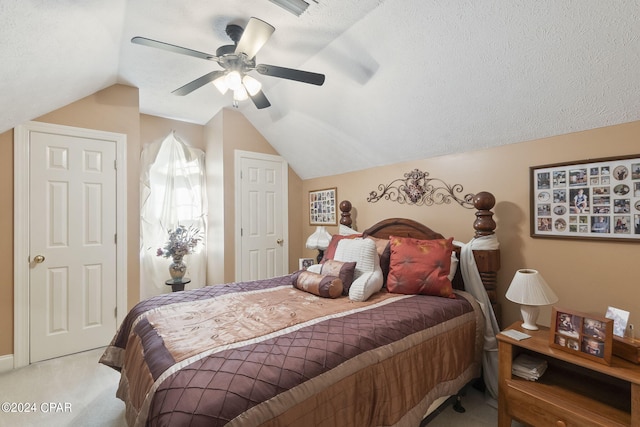 bedroom with ceiling fan, light colored carpet, a textured ceiling, and vaulted ceiling