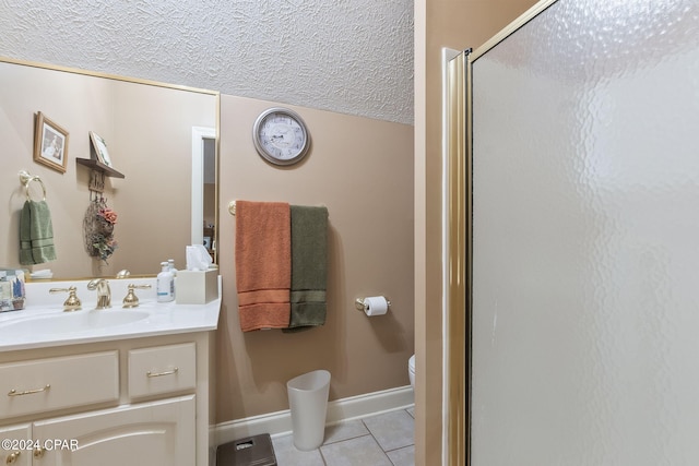 bathroom with a textured ceiling, vanity, tile patterned flooring, toilet, and a shower with shower door