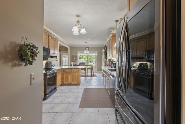 kitchen featuring kitchen peninsula, crown molding, black appliances, pendant lighting, and an inviting chandelier