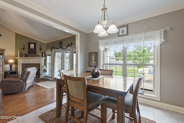 dining area featuring a fireplace, light tile patterned floors, lofted ceiling, and a healthy amount of sunlight