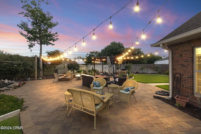 patio terrace at dusk featuring a lawn and outdoor lounge area