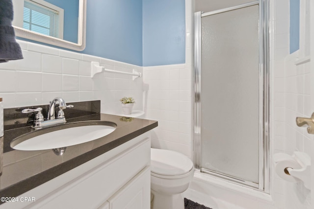 bathroom with tasteful backsplash, vanity, tile walls, and an enclosed shower