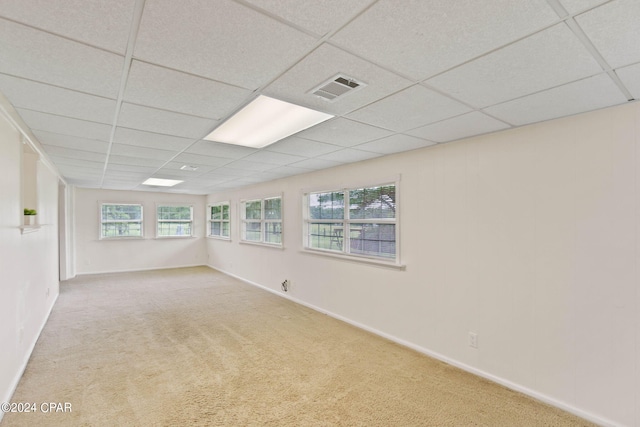 unfurnished room featuring a drop ceiling and light carpet