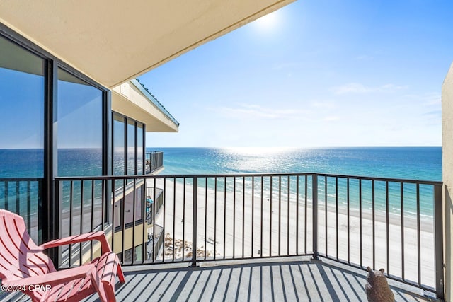 balcony featuring a water view and a beach view